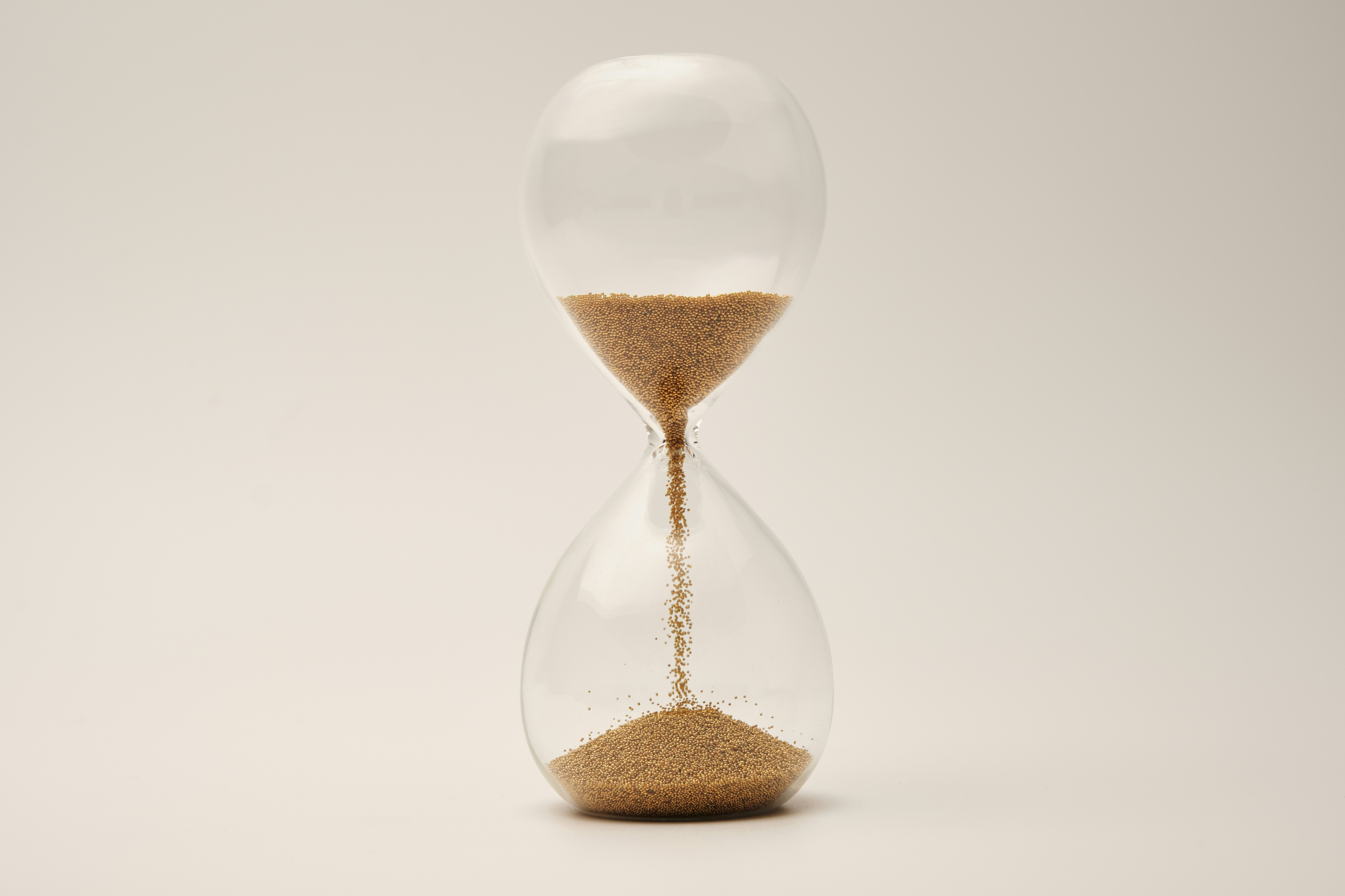 Hourglass with sand representing a biological countdown system for cellular aging.